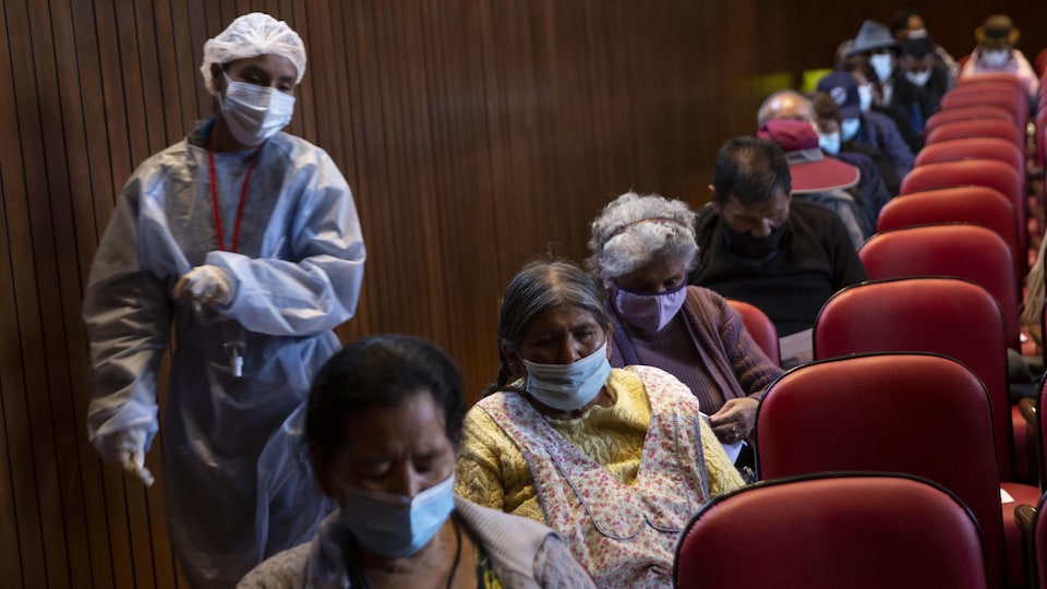 Une travailleuse de la santé surveille des patients qui viennent de recevoir le vaccin Sputnik V à l'Université Mayor de San Andres de La Paz en Bolivie, le 31 mai 2021. 