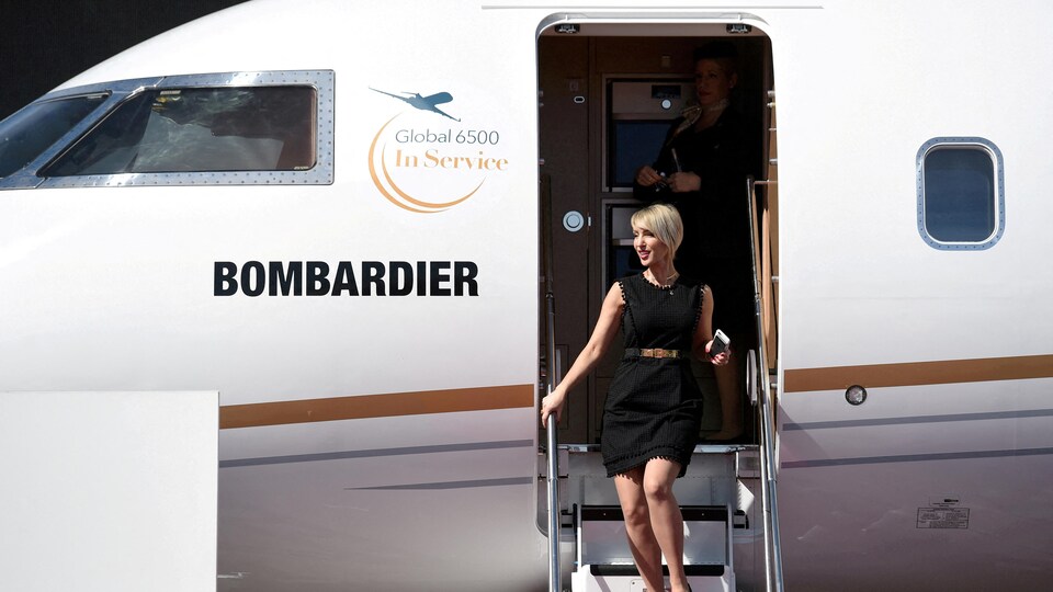 Une femme descend d'un avion de type Global 6500.