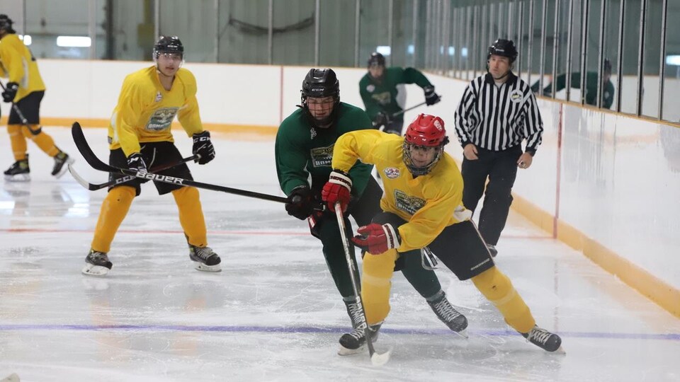 Deux joueurs patinent vers une rondelle.