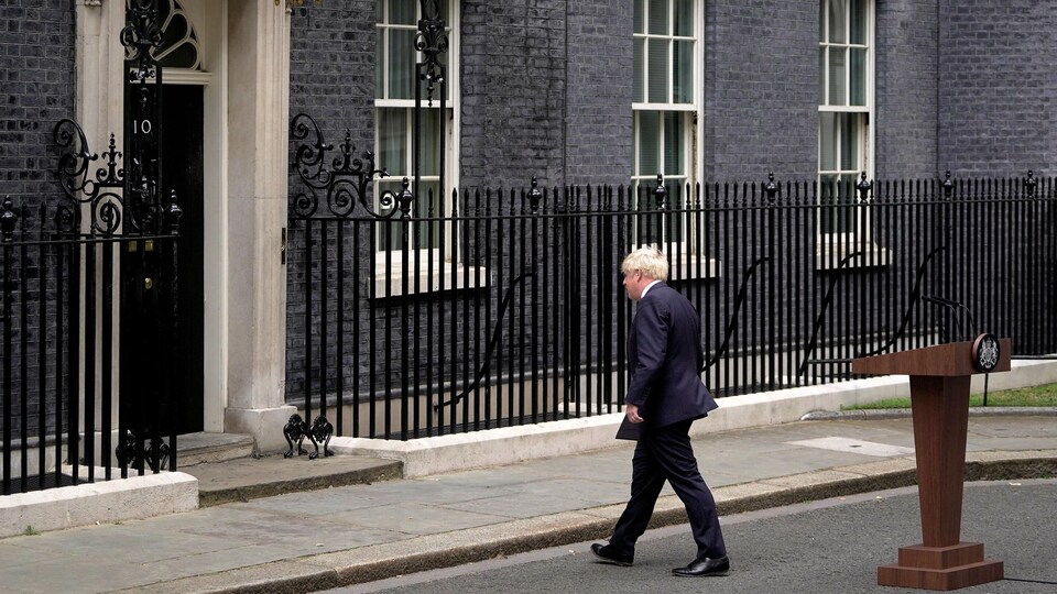 Boris Johnson, de dos, marche vers une bâtisse.
