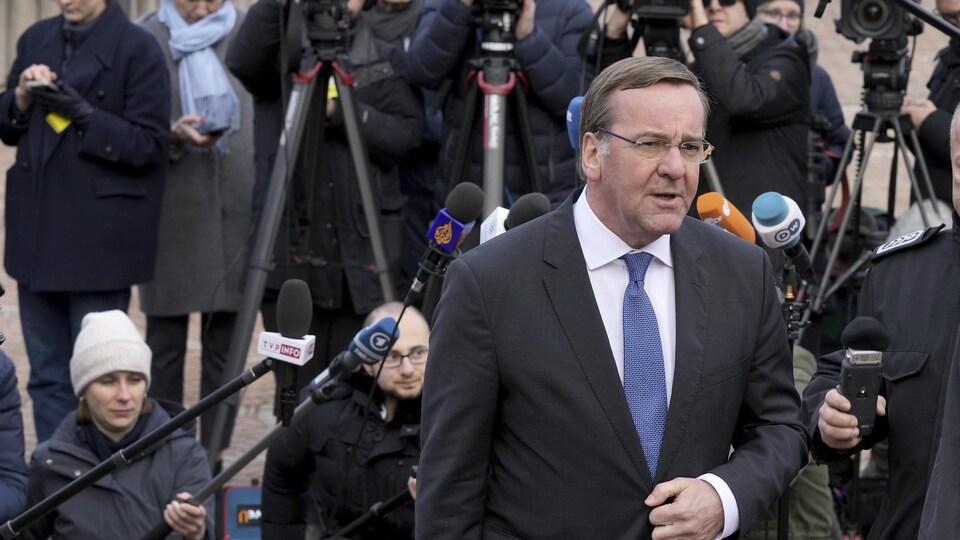 Le ministre allemand de la Défense Boris Pistorius part après une conférence de presse, avec derrière lui de nombreux journalistes.