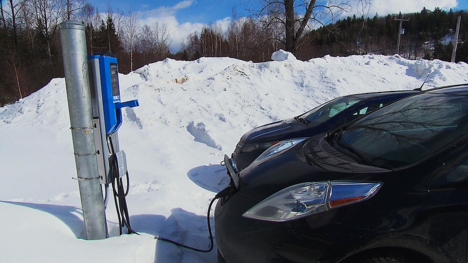 Une voiture électrique branchée à une borne de recharge.