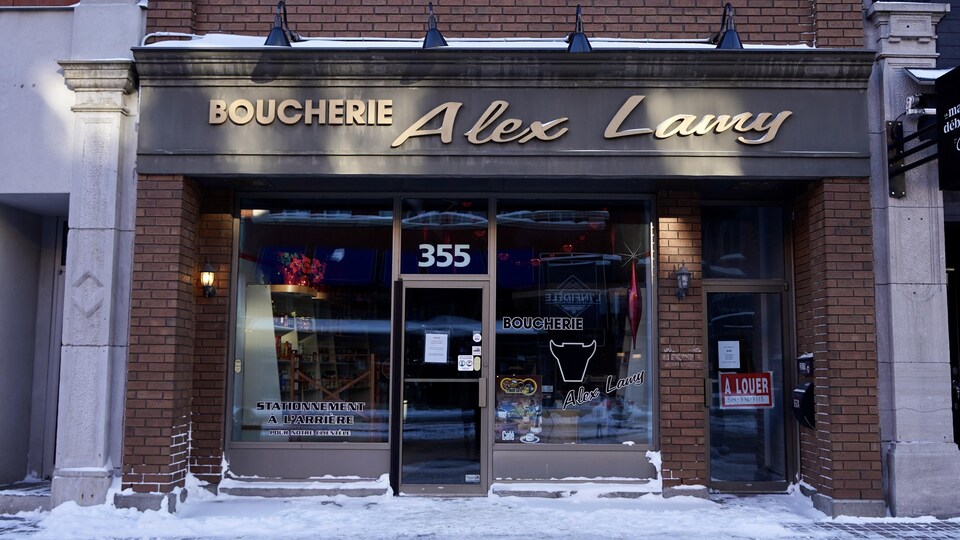 La façade de la Boucherie Alex Lamy montre un commerce fermé. 