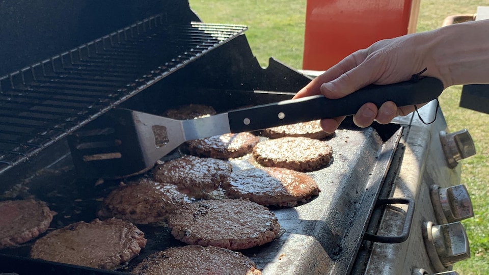 Griller des galettes de hamburger sur un barbecue.