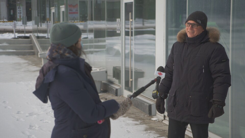 Un homme porte-parole d'un syndicat d'enseignants en entrevue avec une journaliste de Radio-Canada.