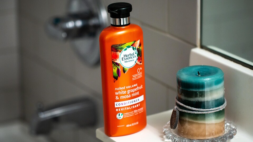 Une bouteille de shampoing orange et opaque.