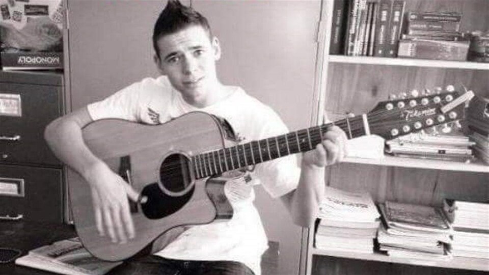 Un jeune homme qui joue de la guitare.