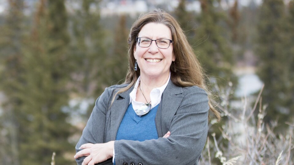 Brenda Stanton posant devant des arbres.