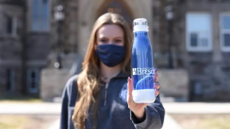 Une étudiante tient une bouteille d'eau réutilisable sur laquelle il est inscrit Brescia University College.