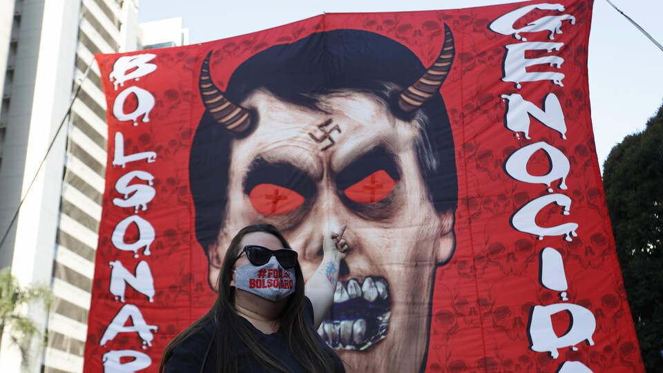 Une affiche géante sur laquelle on devine la tête de Jair Bolsonaro en diable.