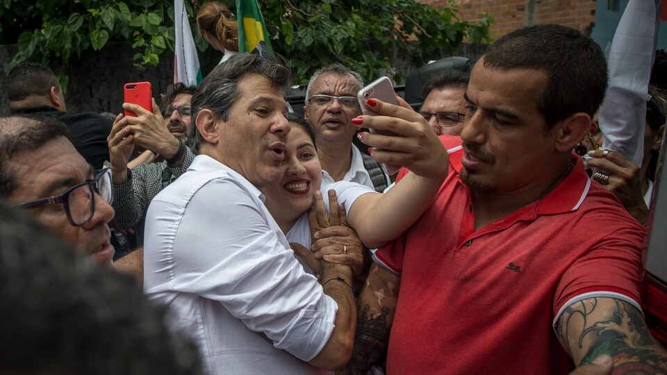 Le candidat de gauche, Fernando Haddad, prenant un égoportrait avec une partisane lors d'un rassemblement à Heliopolis, la plus grande favéla de Sao Paulo.