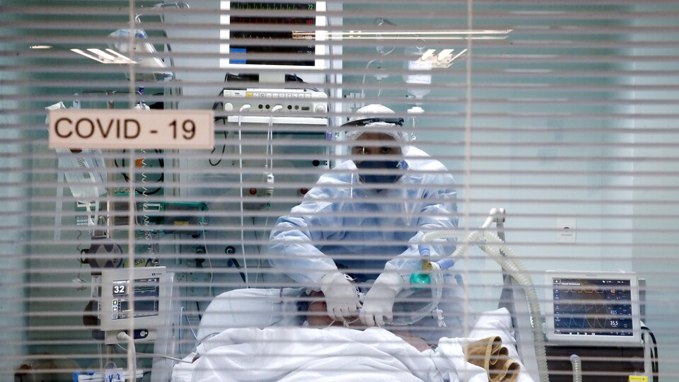 Un travailleur de la santé semble ajuster un masque sur le visage du patient.