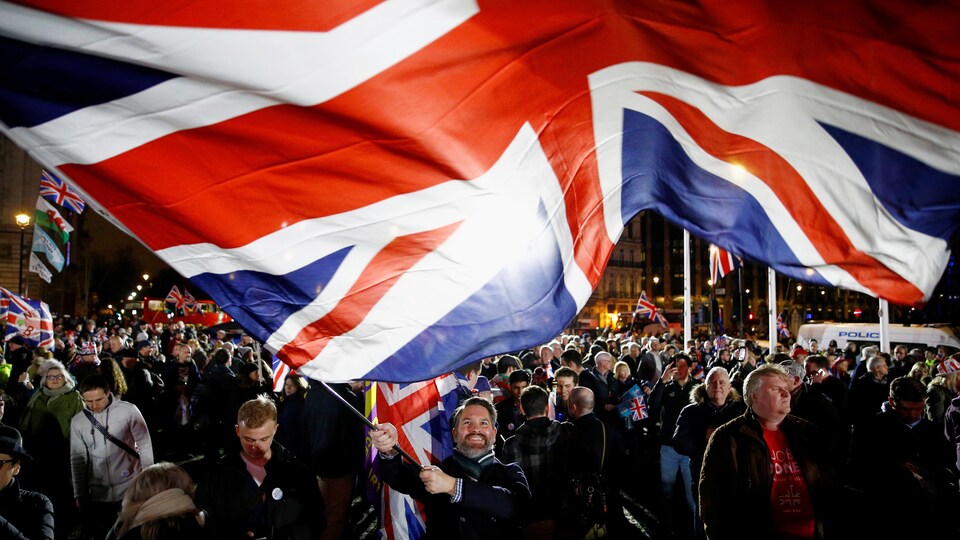 Un homme dans la foule tient un immense drapeau britannique.