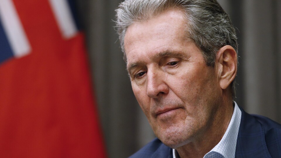 Brian Pallister est photographié en gros plan; il a un air sérieux et son regard est tourné vers le bas.
