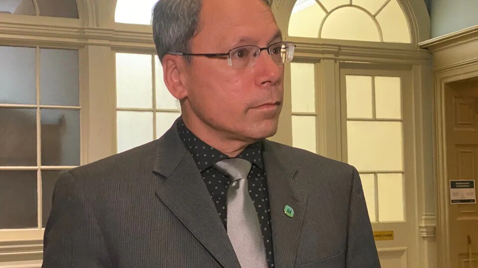 Brian Wong répond aux journalistes à l'Assemblée législative.