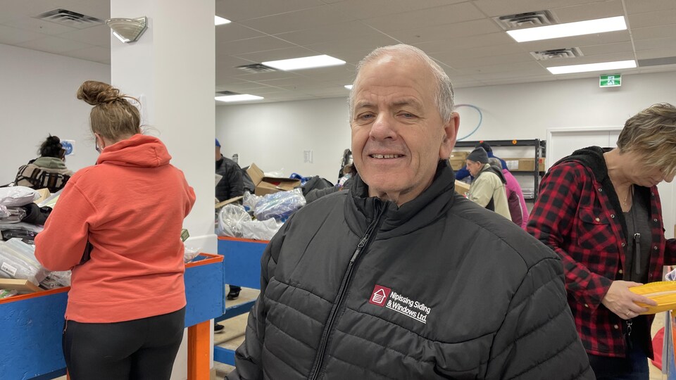 Bruce Casabon avec un manteau noir dans un magasin. 