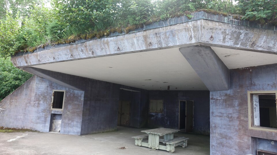 Un bunker vu de l'extérieur servant aujourd'hui d'aire de repos avec une table de pique-nique.