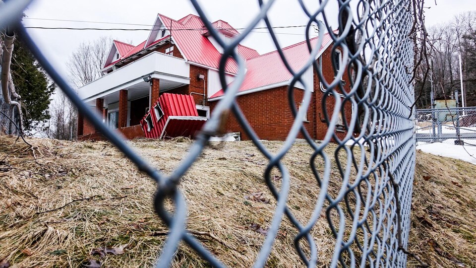 Vue du bunker des Hells Angels de Sherbrooke à travers une clôture industrielle