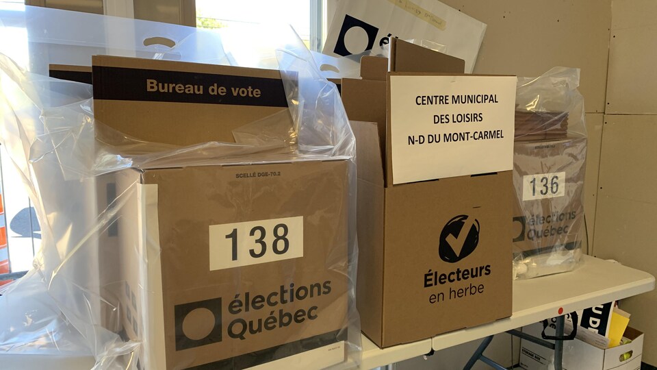 Des boîtes de scrutin déposées sur une table.