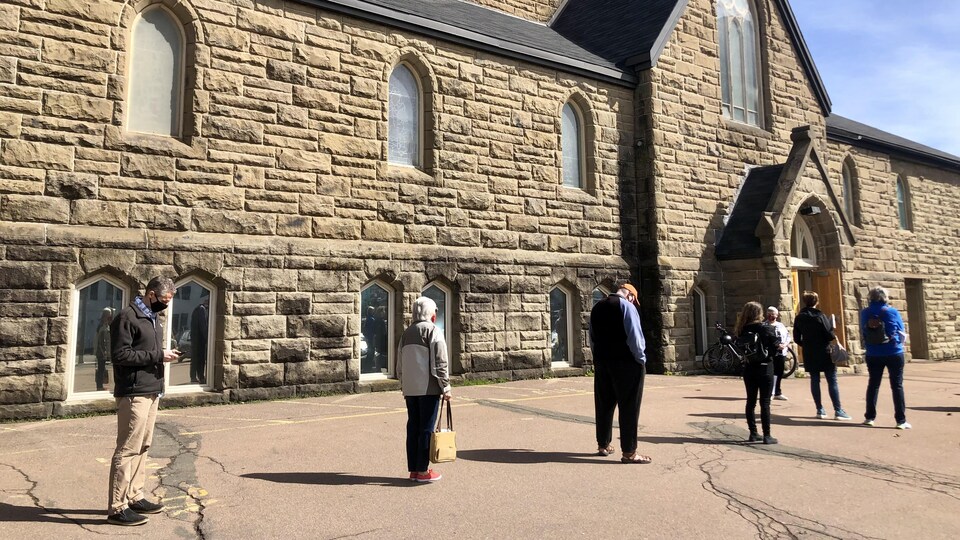 Des gens font la queue devant une église.