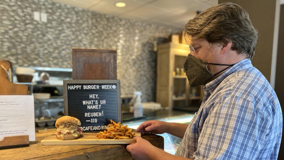 Un restaurateur pose un hamburger sur le comptoir le 1er septembre 2021.