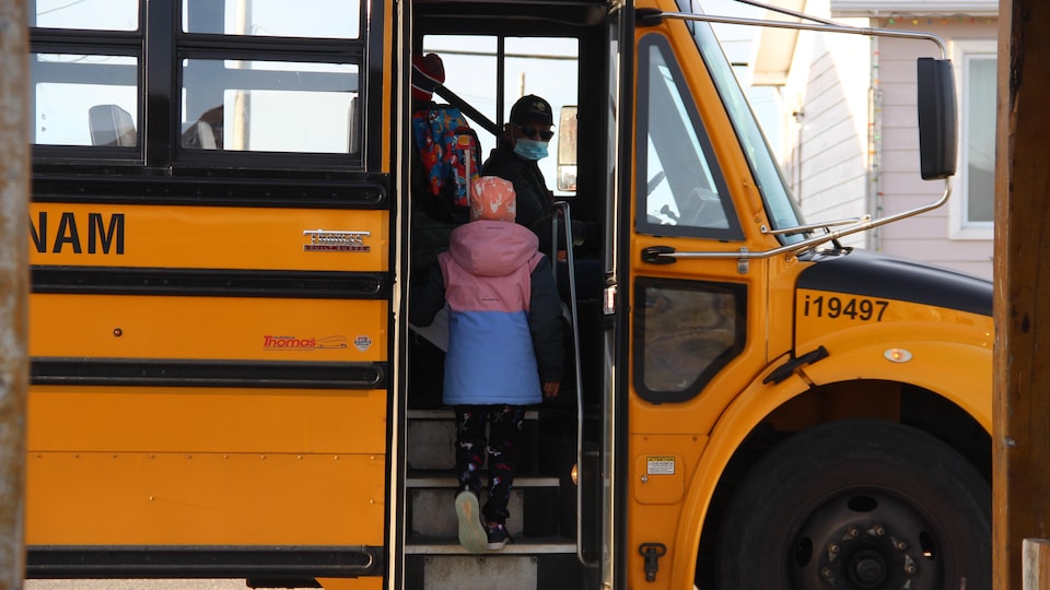 Des enfants qui montent dans un bus scolaire.