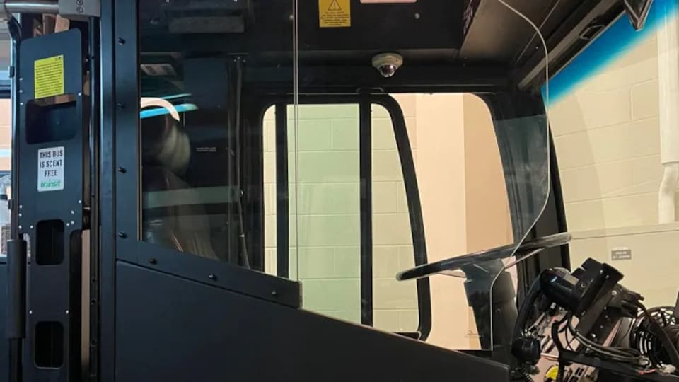 Une porte vitrée protège le poste de chauffeur dans un bus de Saskatoon.
