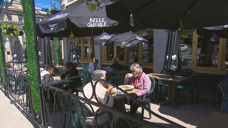 Deux femmes boivent un café sur une terrasse.