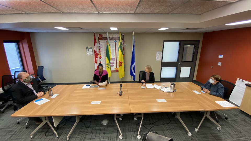 Table avec quatre personnes, respectant une distance de deux mètres.