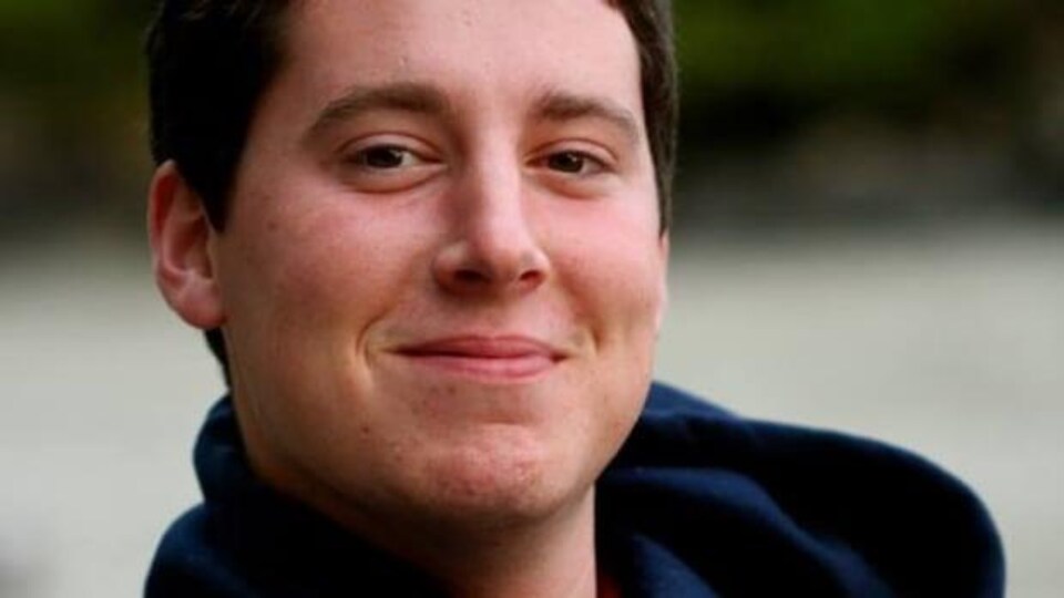 Un jeune homme souriant.