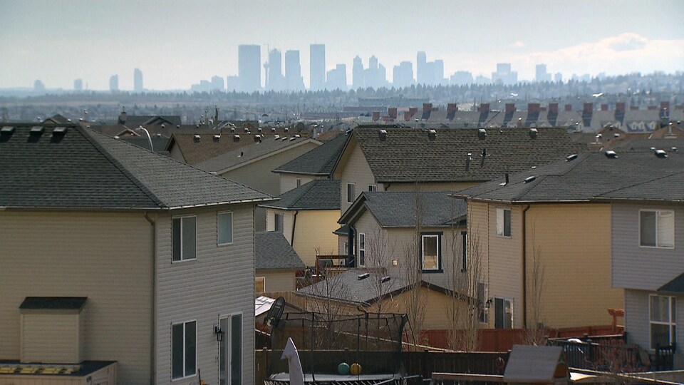 En avant-plan, quelques maisons de banlieue, et en arrière-plan, les tours du centre-ville de Calgary.