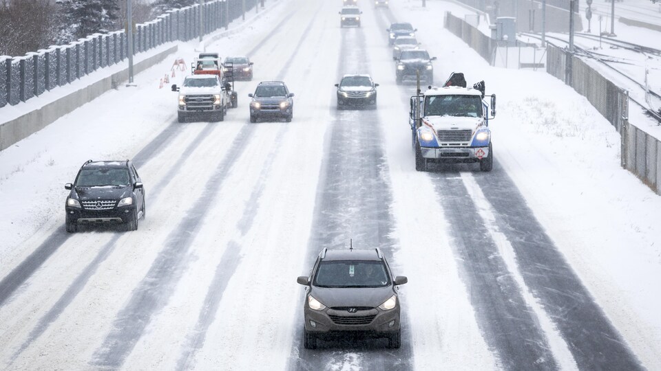 Des automobiles circulent lentement sur une route enneigée à Calgary le 7 novembre 2022.