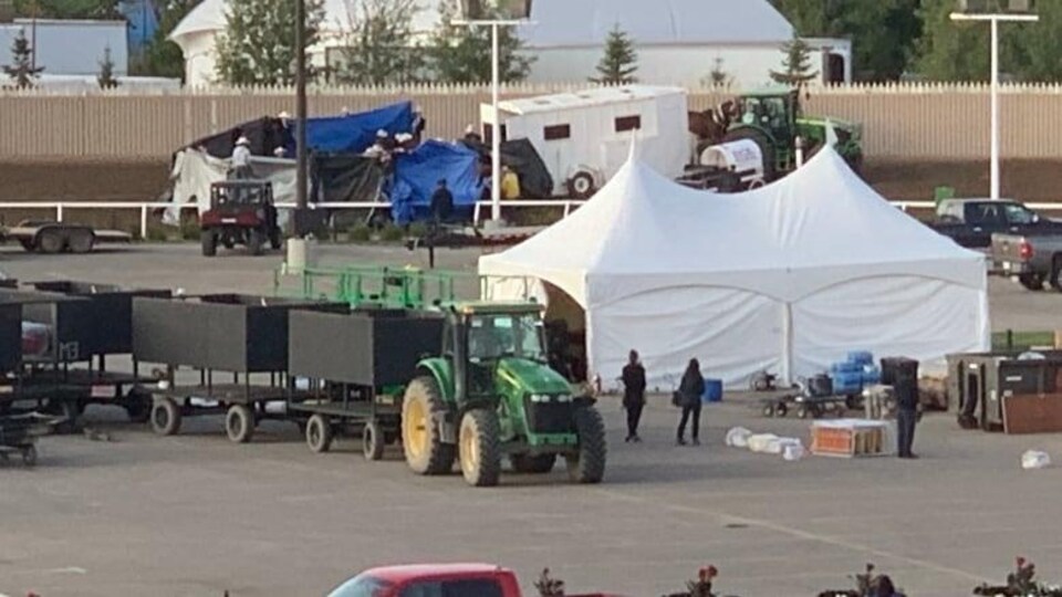 une bâche, une tente et des personnes debout près d'une piste de course