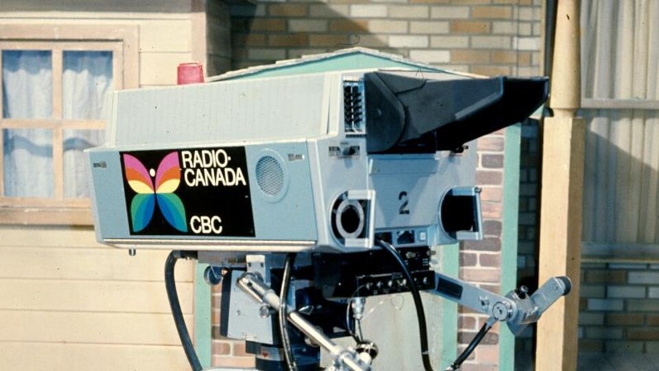 Caméra de télévision couleur avec un autocollant du papillon de Radio-Canada sur un plateau d'une émission jeunesse.