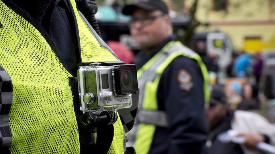 Une petite caméra est accrochée devant la poitrine d'un agent de police.