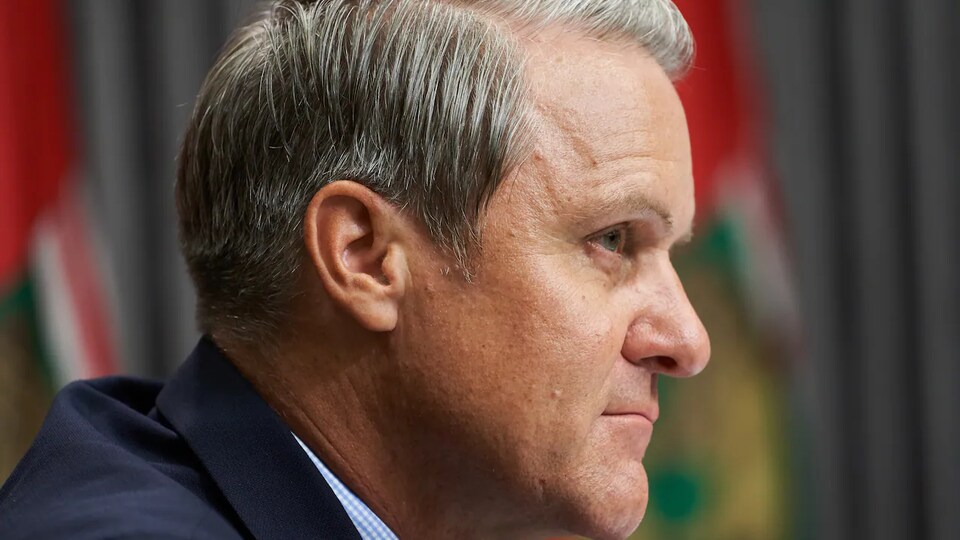 Le ministre des Finances du Manitoba, Cameron Friesen se tient debout, de profil. 