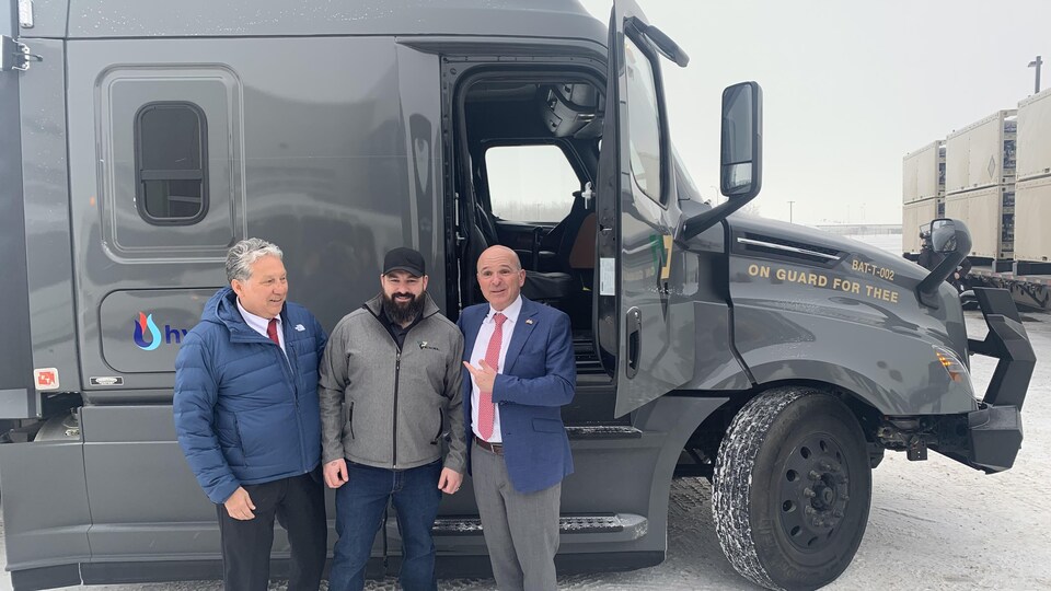 Trois hommes posent devant un camion. Le conducteur se trouve au milieu. À sa droite se trouve Daniel Vandal et à sa gauche le ministre du Tourisme et ministre associé des Finances, Randy Boissonnault. (17 janvier 2023)