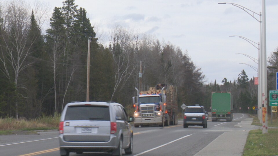 Un camions de bois sur la route.