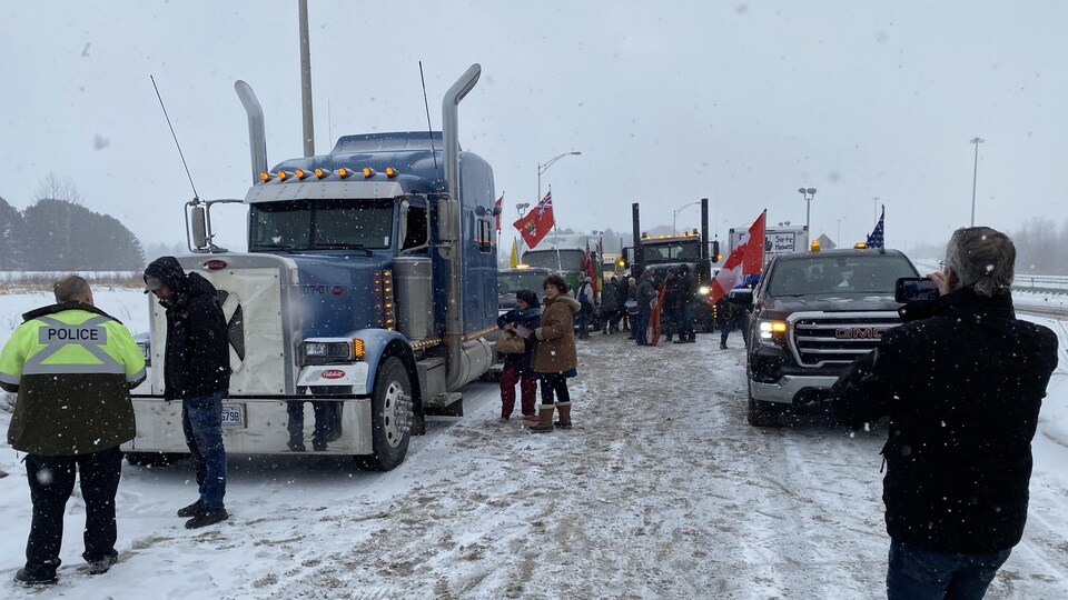 Des camions et voitures sont rassemblés avec des drapeaux du Canada.