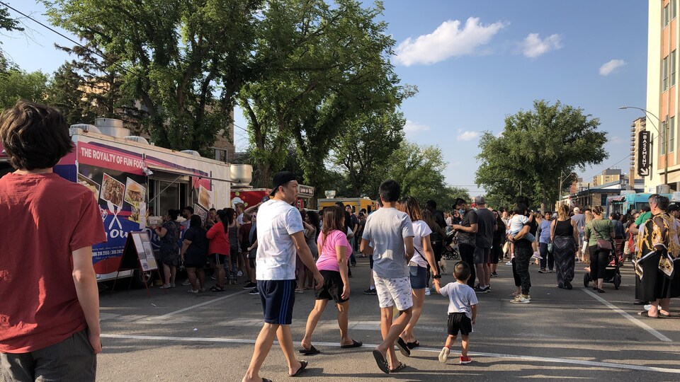Des passants circulent et font la file devant des camions-restaurants.