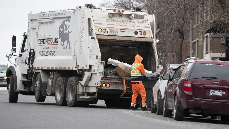 Un éboueur fait la collecte des ordures.