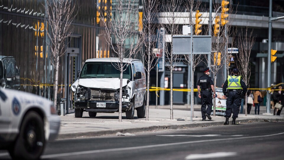 Deux policiers marchent près de la camionnette utilisée par le tueur.