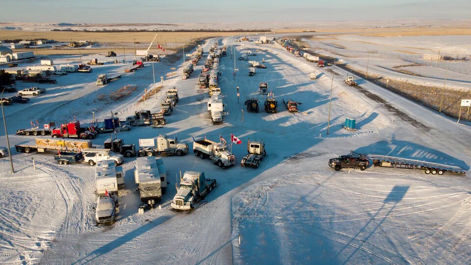 Des dizaines de camions sont alignés et à l'arrêt près de poste-frontière de Coutts, en Alberta.