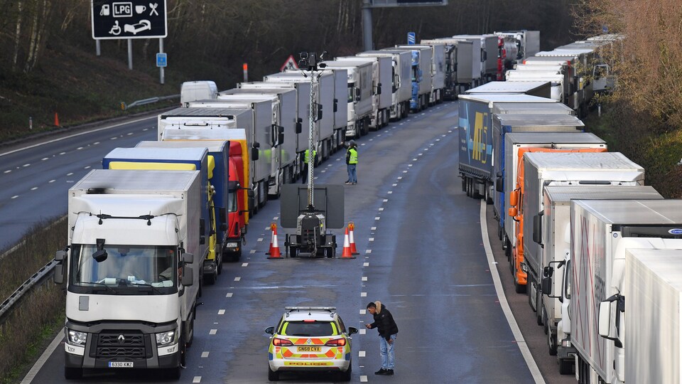 Deux rangées de camions immobilisés le long de la route.