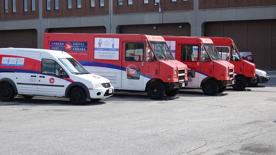Des camions de Postes Canada dans un stationnement.