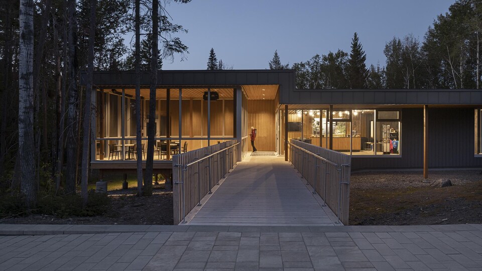 Un pavillon en bois vu de l'extérieur en début de soirée.