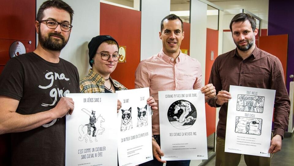 Les quatre individus responsables de la campagne de promotion tiennent les fameuses affiches en souriant.