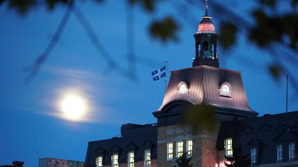 Pleine lune derrière le campanile de l'Université du Québec à Rimouski.