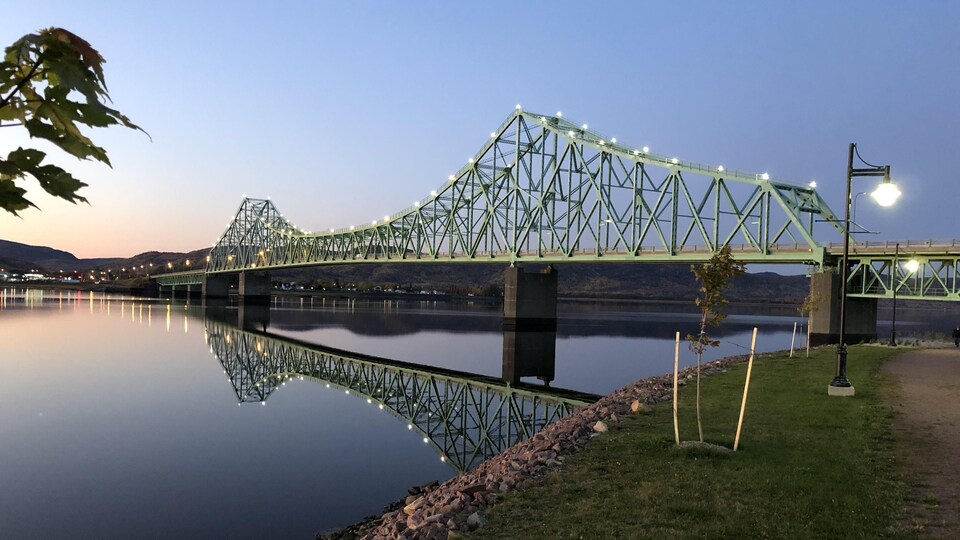 Le pont est illuminé tandis que le jour tombe.