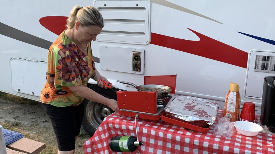 Michelle Warren allume un réchaud de camping.